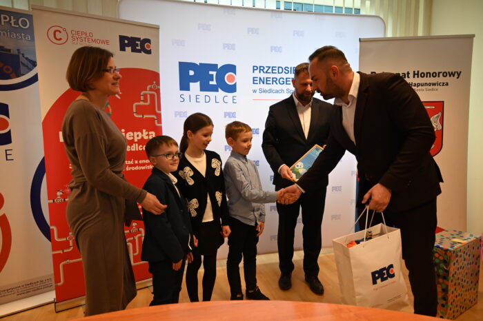 Naczelnik Gabinetu Prezydenta Miasta Siedlce Piotr Woźniak, Prezes Zarządu PEC Siedlce Wojciech Pawlik oraz laureatka projektu wraz z uczniami