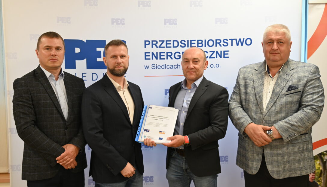 Od lewej strony na zdjęciu: Członek Zarządu Dariusz Napiórkowski, Prezes Zarządu Wojciech Pawlik, Prezes Zarządu PEC Serwis Dariusz Kruk, Vice Prezes Zarządu Kobyliński Janusz. Prezesi trzymają podpisaną umowę.