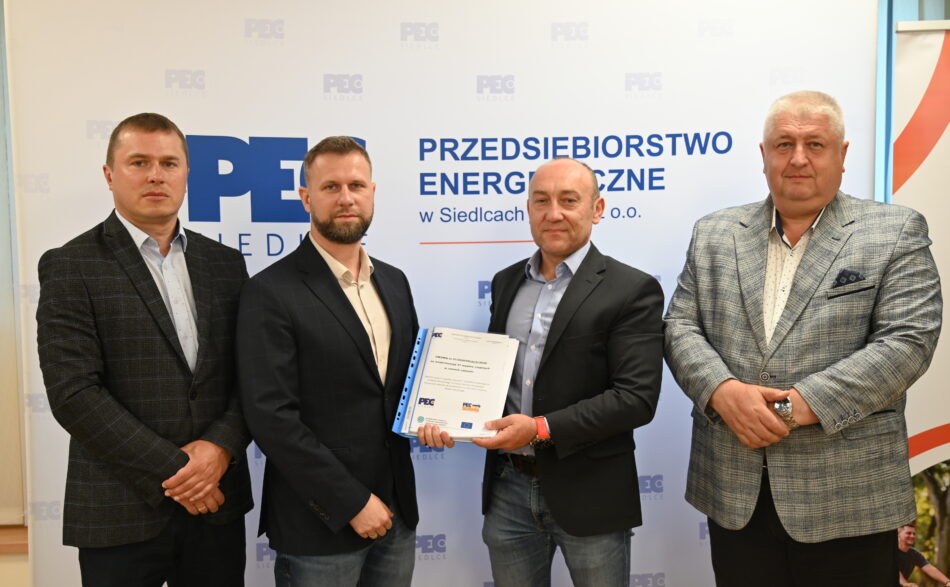 Od lewej strony na zdjęciu: Członek Zarządu Dariusz Napiórkowski, Prezes Zarządu Wojciech Pawlik, Prezes Zarządu PEC Serwis Dariusz Kruk, Vice Prezes Zarządu Kobyliński Janusz. Prezesi trzymają podpisaną umowę.